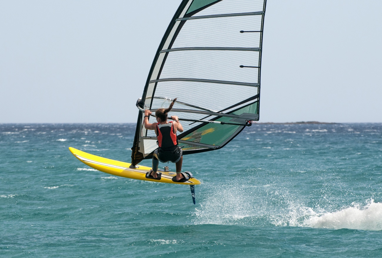 Windfoiler flying above the water